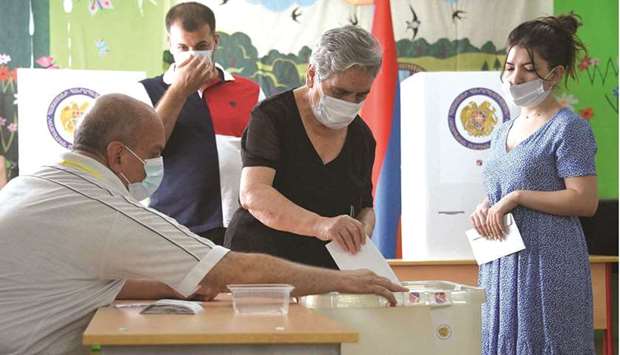 People cast their ballots at a polling station during early parliamentary elections in Yerevan yesterday. (AFP)