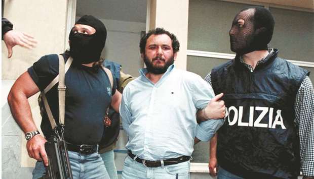 Anti-Mafia police wearing masks to hide their identity, escort top Mafia fugitive Giovani Brusca as he leaves Palermou2019s police headquarters to be taken to a maximum security prison. (Reuters)