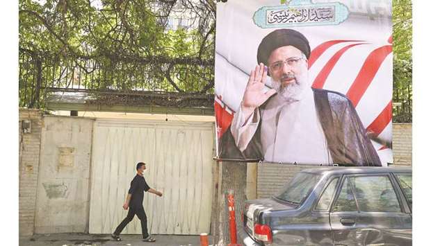 A pedestrian walks by an electoral poster of judiciary chief and presidential candidate Ebrahim Raisi in the Iranian capital Tehran yesterday. The presidential elections are scheduled for June 18.