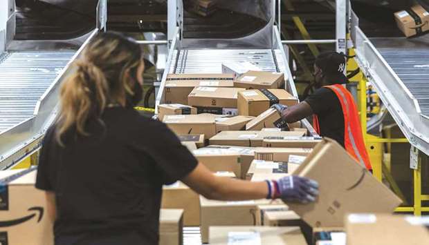 Workers retrieve boxes at an Amazon fulfilment centre on Prime Day in Raleigh, North Carolina. Amazon.com uses Prime Day deals to boost the number of subscribers to the programme.