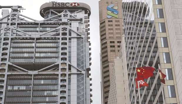 The HSBC Holdings building (left) and the Standard Chartered building stand in Hong Kong. Global banks including HSBC and Standard Chartered are ramping up hiring to tap into Chinau2019s latest market opening u2013 a new investment link with Hong Kong that could yield almost $500mn a year in fees.