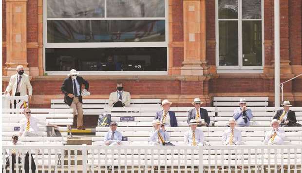 Spectators observe social distancing rules as they watch the first day of the first Test match between England and New Zealand at Lordu2019s Cricket Ground in London yesterday. (AFP)