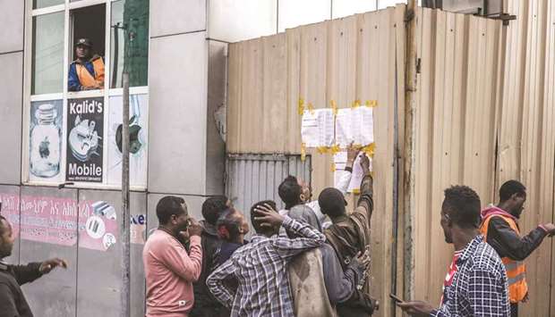 Ethiopian voters look at tallies posted outside a polling station in Addis Ababa, yesterday.