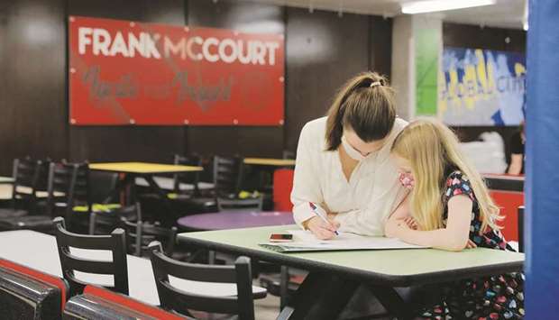 A mother and her daughter fill a ballot at a cafeteriau2019s table in a polling station at the Frank McCourt High School during the New York City primary mayoral election in New York City yesterday. (Reuters)