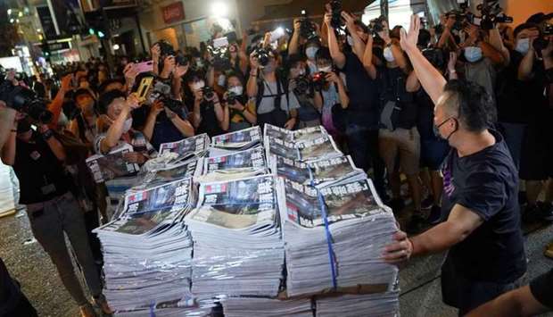 A man gestures as he brings copies of the final edition of Apple Daily, published by Next Digital, to a news stand in Hong Kong, China on June 24. REUTERS