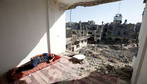 A Palestinian man sleeps in the ruins of his house that was destroyed in Israeli air strikes during Israeli-Palestinian fighting, in Gaza on June 9. REUTERS