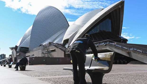A worker cleans public seating outside the Opera House in Sydney, after authorities locked down several central areas of Australia's largest city to contain an outbreak of the highly contagious Delta variant. AFP