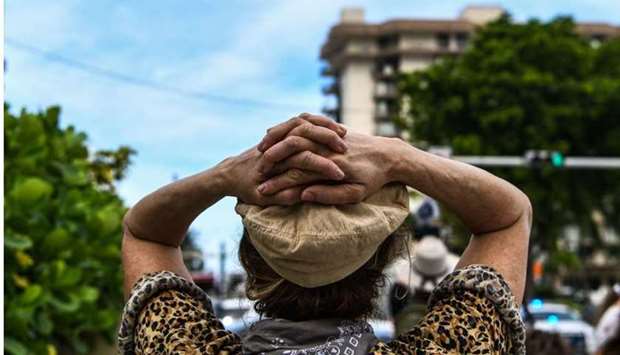 A woman reacts as she watches rescue workers searching the rubble at the site of a collapsed building in Surfside, Florida, north of Miami Beach, on June 26.