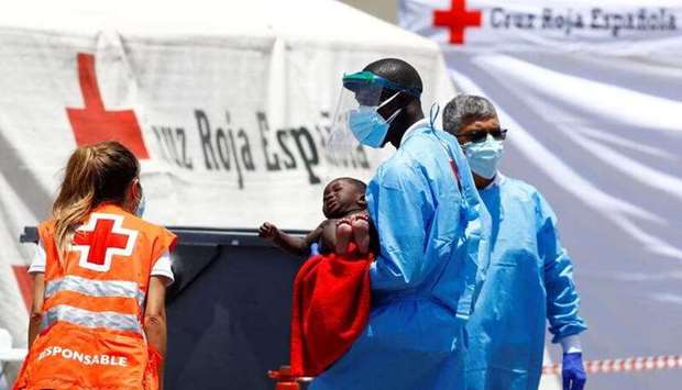 A minor migrant is transferred to a Red Cross tent, in the port of Arguineguin, on the island of Gran Canaria, Spain.