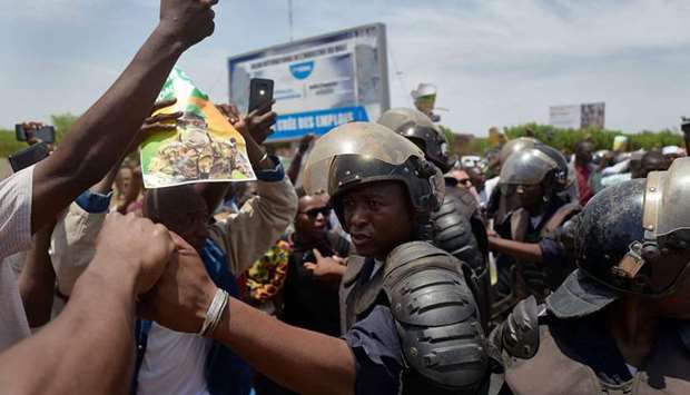 Malian riot police keep supporters away from the vehicle of new President of Mali's transitional government Assimi Goita as he returns from Accra after a meeting with the ECOWAS (The Economic Community of West African States) representatives
