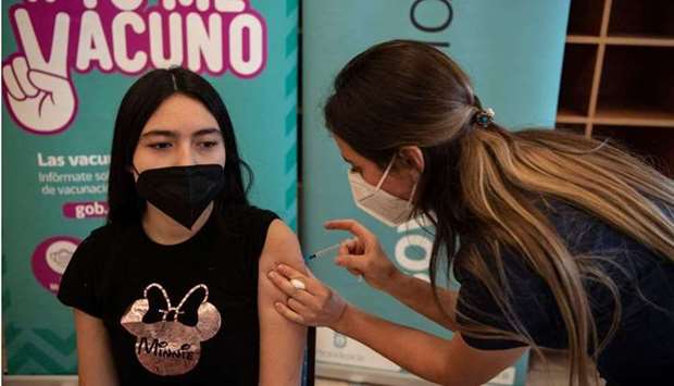 A health worker administers a dose of the Pfizer-BioNTech vaccine against Covid-19 to a minor at a vaccination centre in Santiago, on June 23, 2021