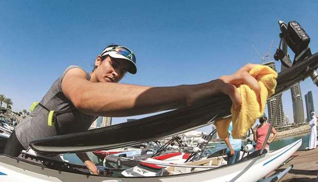 Qatari rower and Olympic hopeful Tala Abujbara, 28 (also right), cleans her scull boat at a marina in Doha. She is building up momentum from a second place finish at the womenu2019s single sculls final at the World Championships in Linz, Austria in 2019 as she heads to Tokyo.