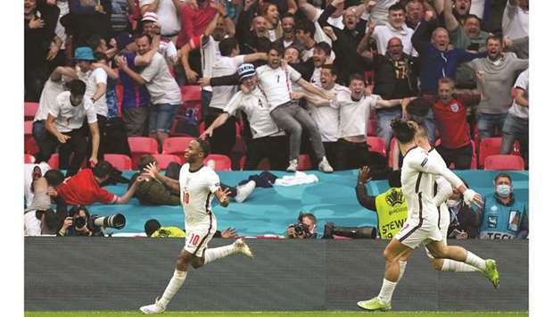 Englandu2019s forward Raheem Sterling (L) celebrates after scoring the opening goal against Germany at Wembley Stadium in London yesterday.