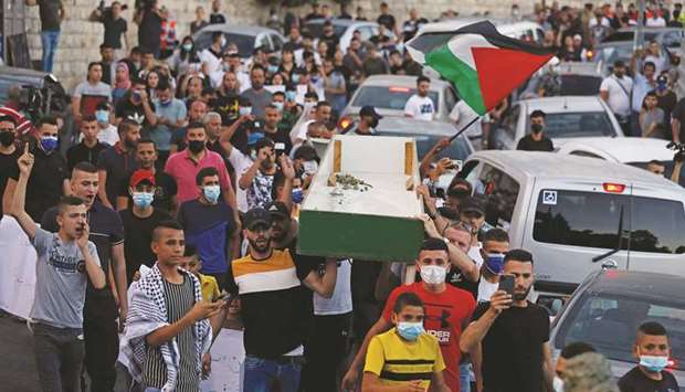 Palestinian protesters march in a symbolic funerary parade in the annexed east Jerusalemu2019s predominantly Arab neighbourhood of Silwan yesterday, during a protest over Israelu2019s planned evictions of Palestinian families from homes in the eastern sector.
