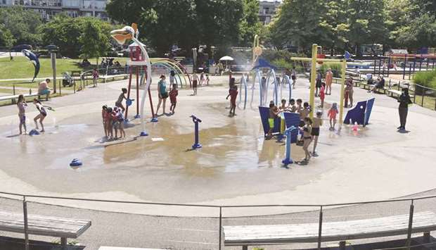 Children cool off at a community water park on a scorching hot day in Richmond, British Columbia.