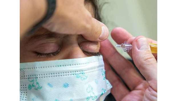 The special eye drops made from human plasma or serum containing plasminogen being administered.