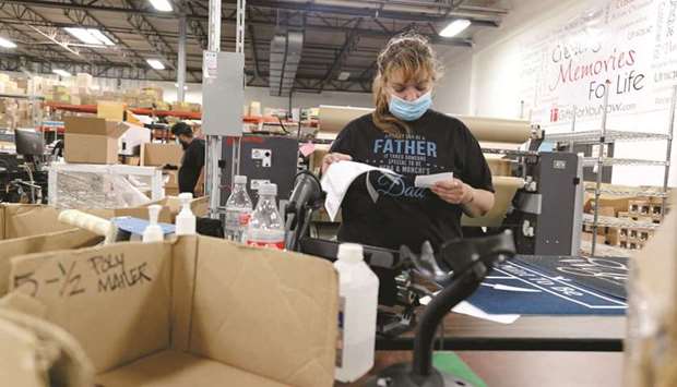 An employee wearing a protective masks reviews paperwork at the Gifts For You company warehouse in Woodridge, Illinois. Initial claims for state unemployment benefits fell 20,000 in the US to a seasonally adjusted 385,000 for the week ended May 29.