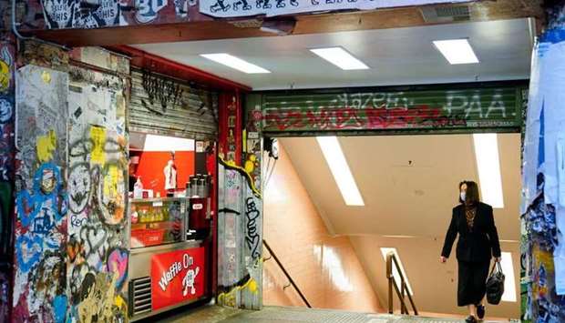 A woman walks past an empty cafe during morning commute hours on the first day of a seven-day lockdown as the state of Victoria looks to curb the spread of a coronavirus disease (COVID-19) outbreak in Melbourne, Australia, May 28, 2021. (REUTERS)