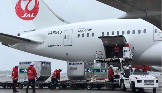 Workers load vaccines against the coronavirus disease (Covid-19) to an airplane before the plane, heading towards Taiwan, takes off from an airport in Narita, Japan