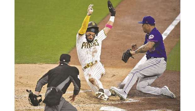 Fernando Tatis Jr (left) of the San Diego Padres scores on a wild pitch ahead of the tag of Taijuan Walker (right) of the New York Mets during the fifth inning of their MLB game at Petco Park in San Diego, California, United States, on Thursday. (AFP)