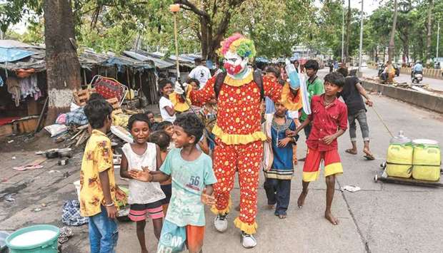 Volunteer social worker Ashok Kurmi, dressed as a clown interacts with children while he sanitises an area and spread awareness to follow the Covid-19 coronavirus safety protocols inside a slum area in Mumbai. Kurmi is helping an army of young fans fight the coronavirus in Mumbaiu2019s slums using an unusual accessory: a clown costume. u201cWith the help of different costumes, I can spread awareness without scaring people. I am able to help them a little,u201d Kurmi said.