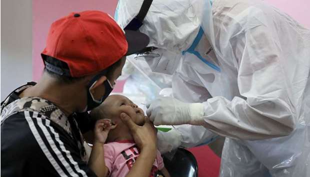 A medical worker collects a swab sample from a baby to be tested for the coronavirus disease (Covid-19) in Cyberjaya, Malaysia