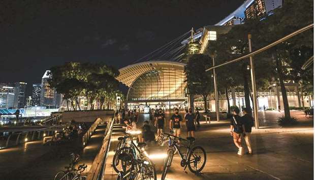 People walk along Marina Bay promenade at night in Singapore on May 15. Many restaurants in the city have embraced simplicity and are offering dishes that were popular during last yearu2019s circuit breaker.