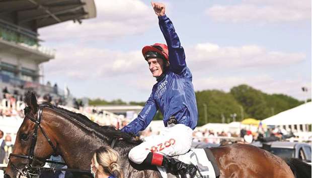 Adam Kirby on Adayar celebrates their winning the Epsom Derby on the second day of the Epsom Derby Festival horse racing event at Epsom Downs Racecourse in Surrey yesterday.