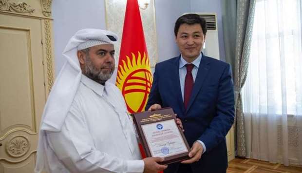 Ulukbek Maripov, Chairman of the Cabinet of Ministers , Kyrgyzstan, hands over a Certificate of Honour and Medal of Honour of the Kyrgyz Republic to Qatar Charity CEO Youssef bin Ahmed al-Kuwari