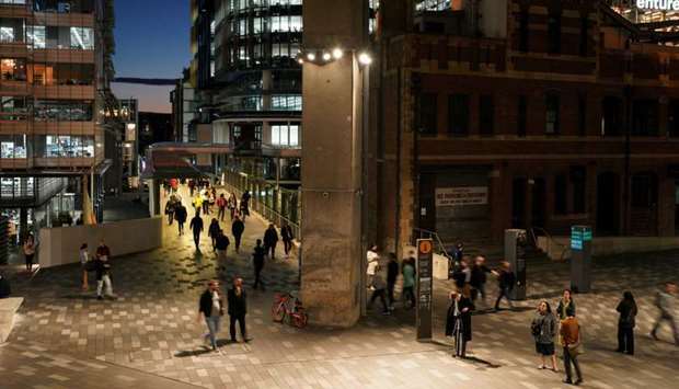 People walk through the Central Business District (CBD) at dusk in Sydney, Australia