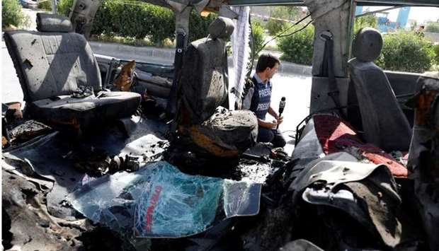 An Afghan journalist reports next to a damaged van after a blast on June 3 in Kabul. Reuters