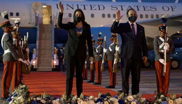 US Vice President Kamala Harris and Guatamala's Foreign Minister Pedro Brolo wave upon her arrival at Guatemalan Air Force Central Command in Guatemala City