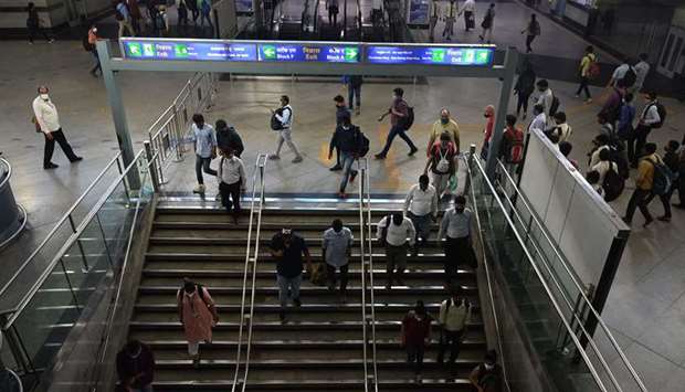 Commuters walk at a metro station after the services were allowed to operate at 50 percent capacity in New Delhi