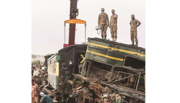 Security personnel carry out rescue operations at the site of a train accident in Daharki area of the northern Sindh province yesterday. (AFP)