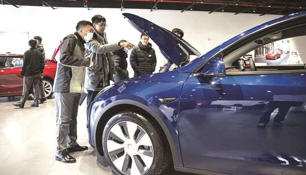 Customers look at a Tesla Model Y electric vehicle at the automakeru2019s showroom in Shanghai. Teslau2019s China shipments rebounded in May from April u2014 when production was temporarily suspended for maintenance u2014 though analysts are watching to see if a run of bad publicity will translate into reduced demand in the months ahead.