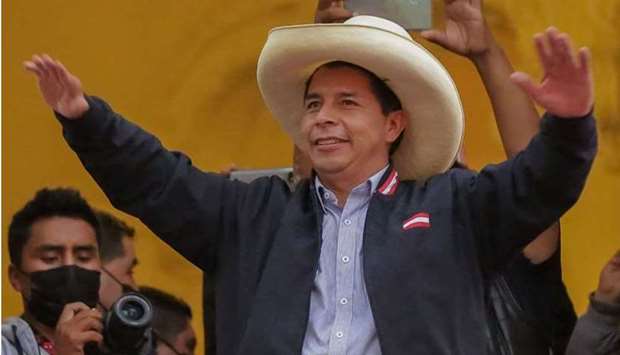 Peruvian presidential candidate Pedro Castillo gestures at supporters from a balcony of his party's headquarters in Lima, after taking a razor-thin lead as the final votes are tallied in a neck-and-neck battle with populist Keiko Fujimori following the runoff election of June 6