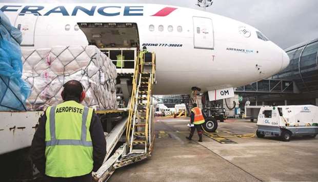 Workers load cargo into the hold of a Boeing Co 777-300ER passenger plane, operated by Air France-KLM, before departure to Los Angeles, at Charles de Gaulle airport in Roissy, France, on May 10. Recent data that air cargo demand continued to outperform pre-Covid levels (April 2019) with demand up 12%, has cheered up the global air transport industry.