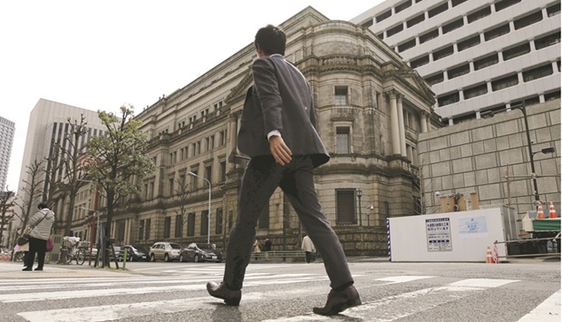 A man walks past the Bank of Japan building in Tokyo. Japanu2019s government and central bank said yesterday they were concerned by recent sharp falls in the yen in a rare joint statement, the strongest warning to date that Tokyo could intervene to support the currency as it plumbs 20-year lows.