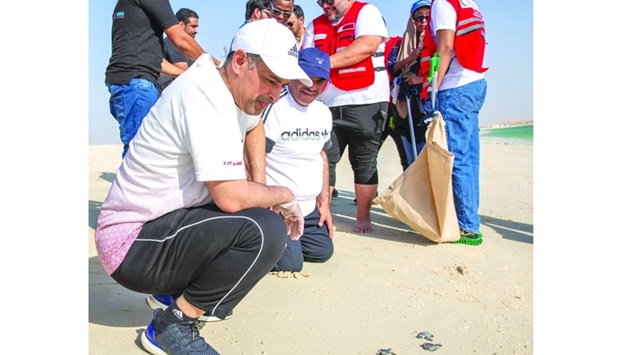 HE the Minister of Environment and Climate Change Sheikh Dr Faleh bin Nasser al-Thani (left) observing Hawksbill turtle hatchlings Friday during the event.
