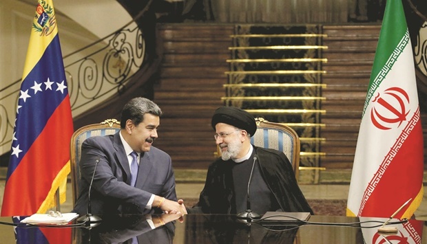 A handout picture provided by the Iranian presidency shows President Ebrahim Raisi  and Venezuelau2019s President Nicolas Maduro shaking hands during a joint statement after their  meeting in the capital Tehran, yesterday.