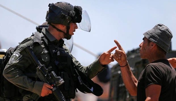 A Palestinian man argues with an Israeli border police officer during a protest against Israeli settlement activity near Hebron in the Israeli-occupied West Bank Saturday. REUTERS