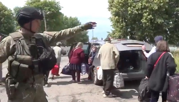 A police officer evacuates people at a location given as Pryvillia town, Luhansk Region, Ukraine in this still image obtained from a handout video released on June. National Police Of Ukraine/Handout via REUTERS