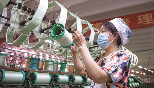A worker produces silk products to be exported at a textile factory in Nantong in Chinau2019s eastern Jiangsu province on Wednesday. The uptick in the industrial sector was underpinned by the easing of Covid curbs and strong global demand.