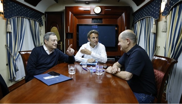 French President Emmanuel Macron (C), German Chancellor Olaf Scholz (R) and Italian Prime Minister Mario Draghi (L) travel on board a train bound to Kyiv after departing from Poland on June 16, 2022.