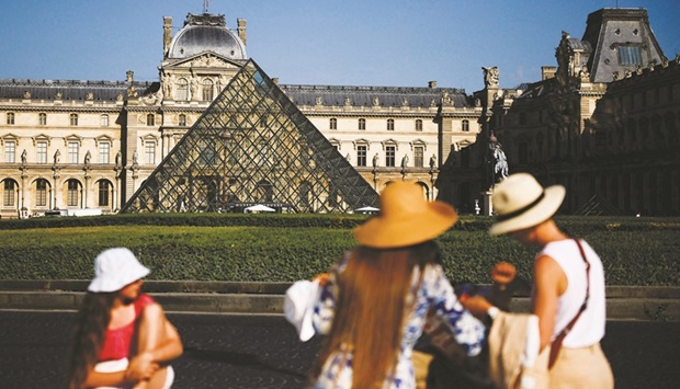Tourists take a picture in front of the glass Pyramid of the Louvre museum in Paris this week. (Reuters)