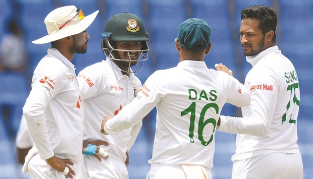 Shakib Al Hasan (right) and Mahmudul Hasan Joy (second right) of Bangladesh celebrate the dismissal of Nkrumah Bonner of West Indies during the second day of the first Test against the West Indies at Vivian Richards Cricket Stadium in North Sound, Antigua and Barbuda, yesterday. (AFP)