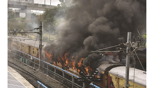 Smoke billows from a passenger train coach after it was set on fire by protesters during a protest against u201cAgnipath schemeu201d for recruiting personnel for armed forces, in Secunderabad in the southern state of Telangana, India, yesterday.