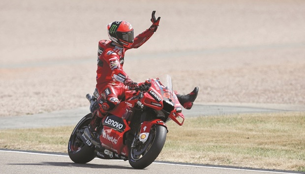 Ducatiu2019s Italian rider Francesco Bagnaia celebrates after taking the pole position for the German MotoGP at the Sachsenring racing circuit in Hohenstein-Ernstthal near Chemnitz, eastern Germany, yesterday. (AFP)