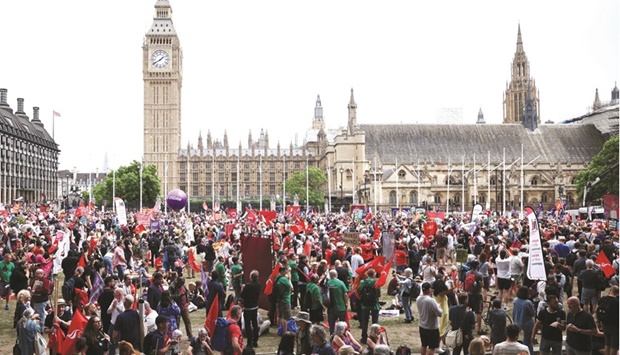 Demonstrators march in a trades union organised protest opposed to British government policies at Parliament Square in London.