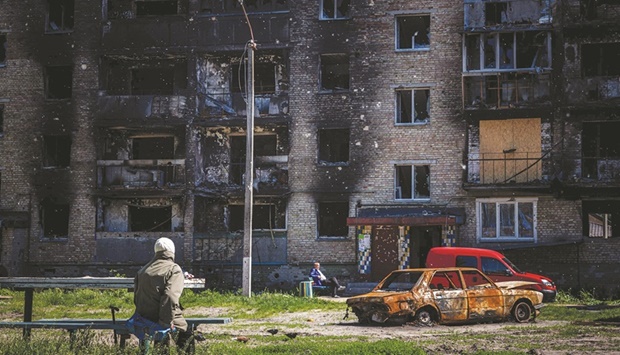 WAR: Local residents sit next to a damaged apartment building in the town of Irpin, near Ukrainian capital Kyiv, last week. (AFP)